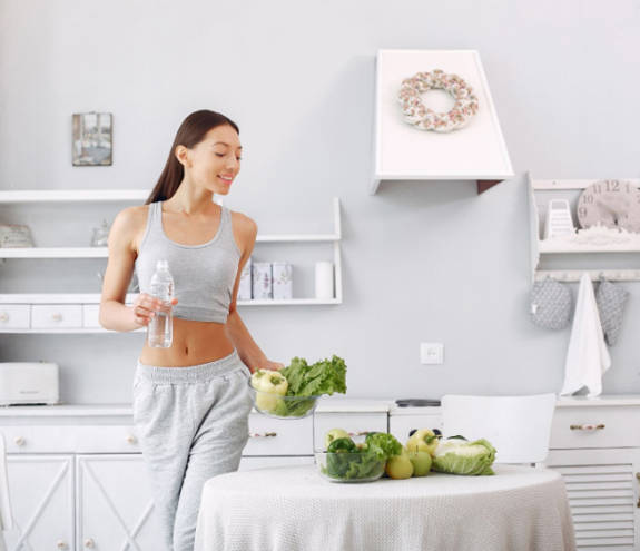 Beautiful Sporty Woman Kitchen With Vegetables