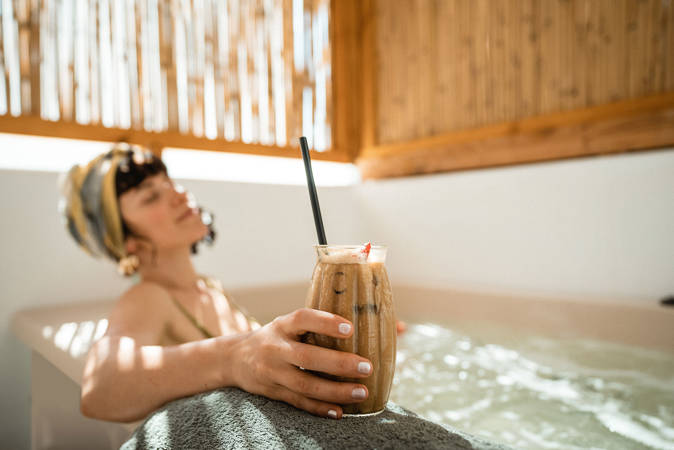 Koukoumi Vegan Hotel master suite visitor enjoying the jacuzzi