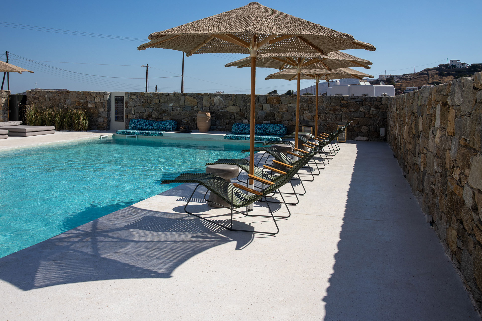 Koukoumi Vegan Hotel pool sunbeds and umbrellas